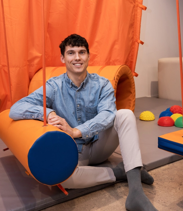 Terapeutas sėdi žaidimų erdvėje